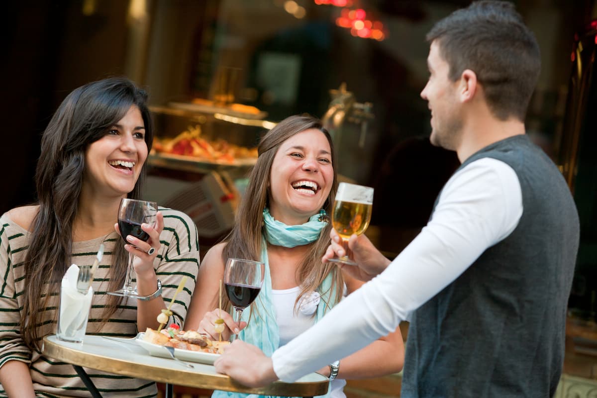 amigos-felices-tomando-vino-cerveza-y-tapas-
